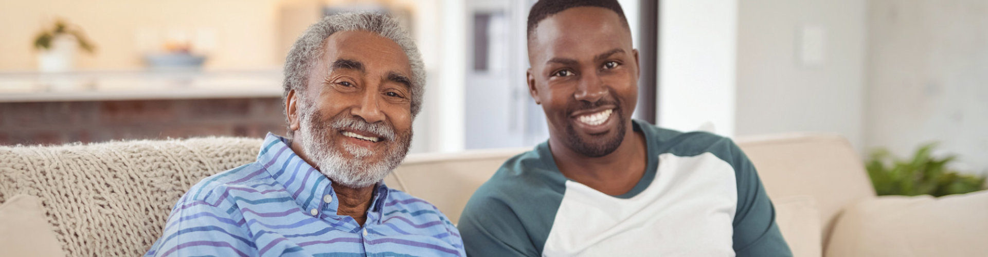 man and senior man smiling while sitting