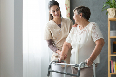 caregiver and senior woman with walker at home